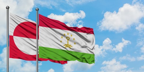 Greenland and Tajikistan flag waving in the wind against white cloudy blue sky together. Diplomacy concept, international relations.