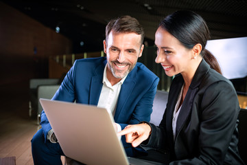 Businesswoman with laptop talking with colleague during meeting