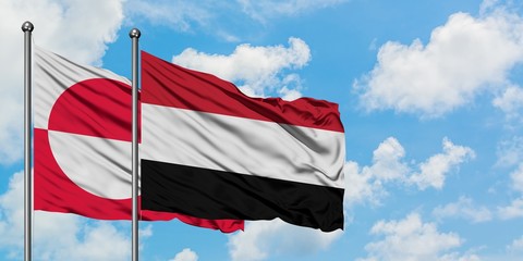 Greenland and Yemen flag waving in the wind against white cloudy blue sky together. Diplomacy concept, international relations.