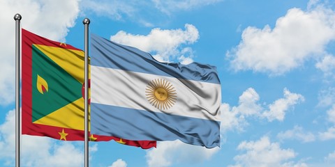 Grenada and Argentina flag waving in the wind against white cloudy blue sky together. Diplomacy concept, international relations.