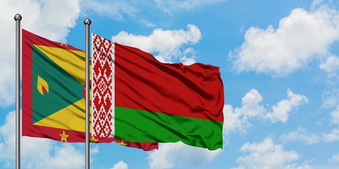 Grenada and Belarus flag waving in the wind against white cloudy blue sky together. Diplomacy...