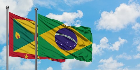 Grenada and Brazil flag waving in the wind against white cloudy blue sky together. Diplomacy...
