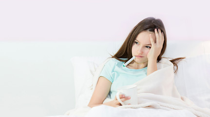 Teen girl lying in bed with a high fever