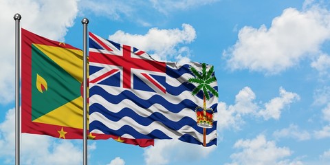 Grenada and British Indian Ocean Territory flag waving in the wind against white cloudy blue sky...
