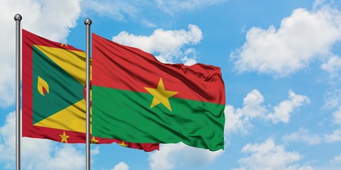 Grenada and Burkina Faso flag waving in the wind against white cloudy blue sky together. Diplomacy concept, international relations.