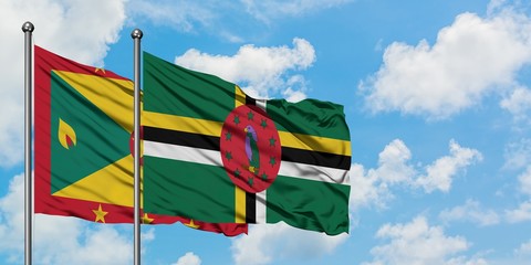 Grenada and Dominica flag waving in the wind against white cloudy blue sky together. Diplomacy...