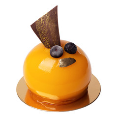 French mousse cake covered with orange glaze isolated on white. Sweet  decorated of gold foil and berries. Apricot modern European dessert with chocolate decoration with gold powder.