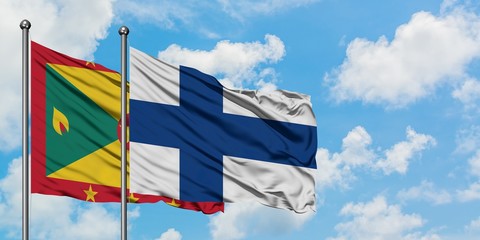 Grenada and Finland flag waving in the wind against white cloudy blue sky together. Diplomacy concept, international relations.