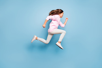Full length body size photo of cheerful side profile positive crazy excited casual preteen wearing pink pants trousers footwear hurrying for discount isolated over pastel blue color background