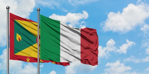 Grenada and Italy flag waving in the wind against white cloudy blue sky together. Diplomacy concept, international relations.