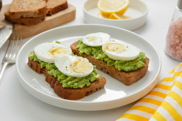 Avocado toast. Sandwich with egg, mashed on wholegrained bread. Healthy breakfast.