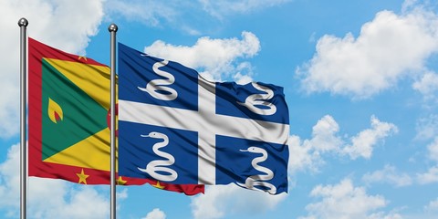 Grenada and Martinique flag waving in the wind against white cloudy blue sky together. Diplomacy...