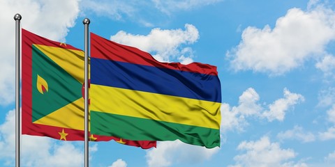 Grenada and Mauritius flag waving in the wind against white cloudy blue sky together. Diplomacy concept, international relations.
