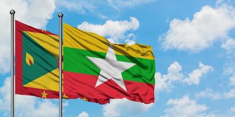 Grenada and Myanmar flag waving in the wind against white cloudy blue sky together. Diplomacy concept, international relations.