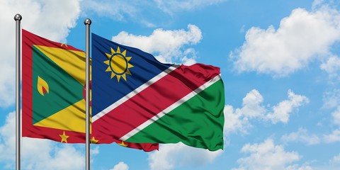 Grenada and Namibia flag waving in the wind against white cloudy blue sky together. Diplomacy concept, international relations.