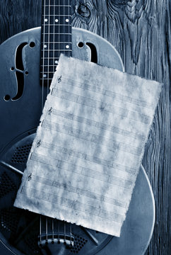 old sheet music on vintage delta bues guitar