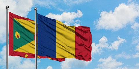 Grenada and Romania flag waving in the wind against white cloudy blue sky together. Diplomacy concept, international relations.