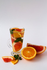 glass of refreshing orange cocktail with green mint on white background. Detox citrus cocktail. healthy lifestyle.
