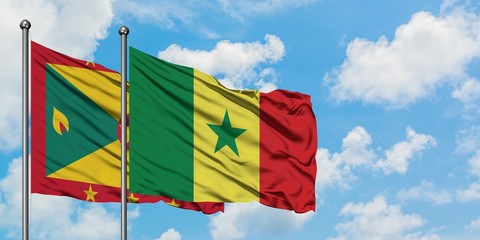 Grenada and Senegal flag waving in the wind against white cloudy blue sky together. Diplomacy...
