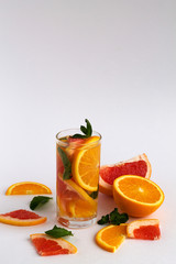 healthy lifestyle. Fresh citrus fruit on white background. refreshing cocktail with slices of fresh orange and grapefruit with green mint leaves on white background. Detox citrus cocktail.