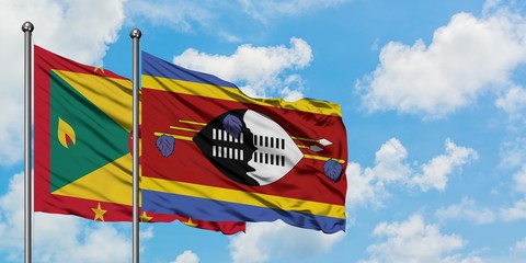 Grenada and Swaziland flag waving in the wind against white cloudy blue sky together. Diplomacy...