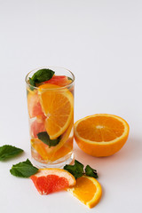 Orange. Detox citrus cocktail. healthy lifestyle. cocktail with slices of fresh orange with green mint leaves on white background.