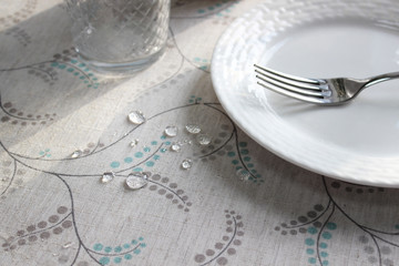  drops of water on the tablecloth on the table, water-repellent layer on the fabric