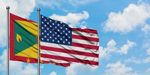 Grenada and United States flag waving in the wind against white cloudy blue sky together. Diplomacy concept, international relations.