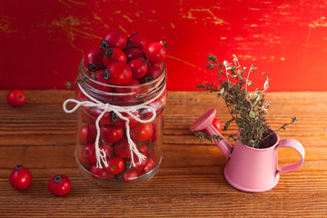 Immunity boosting treatments, infusions. Natural thyme, mint herbs and rosehip berries in a jar on a wooden background.