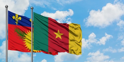 Guadeloupe and Cameroon flag waving in the wind against white cloudy blue sky together. Diplomacy concept, international relations.