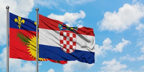 Guadeloupe and Croatia flag waving in the wind against white cloudy blue sky together. Diplomacy concept, international relations.