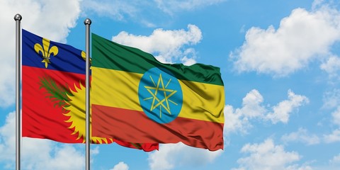 Guadeloupe and Ethiopia flag waving in the wind against white cloudy blue sky together. Diplomacy concept, international relations.