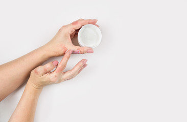 A woman applies cream to her hands to treat dermatitis. Skin diseases. Close-up.