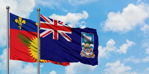 Guadeloupe and Falkland Islands flag waving in the wind against white cloudy blue sky together. Diplomacy concept, international relations.