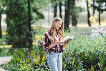 beautiful girl in casual clothes smiling while reading book