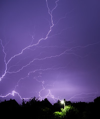 Lightning strikes painting the sky purple in the evening