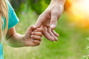 hands of parent and child in nature - obrazy, fototapety, plakaty