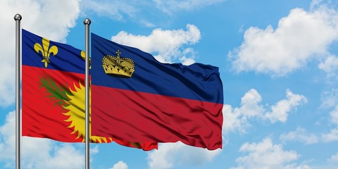 Guadeloupe and Liechtenstein flag waving in the wind against white cloudy blue sky together. Diplomacy concept, international relations.