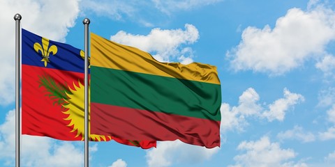 Guadeloupe and Lithuania flag waving in the wind against white cloudy blue sky together. Diplomacy concept, international relations.
