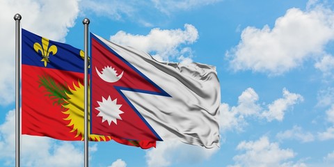 Guadeloupe and Nepal flag waving in the wind against white cloudy blue sky together. Diplomacy concept, international relations.