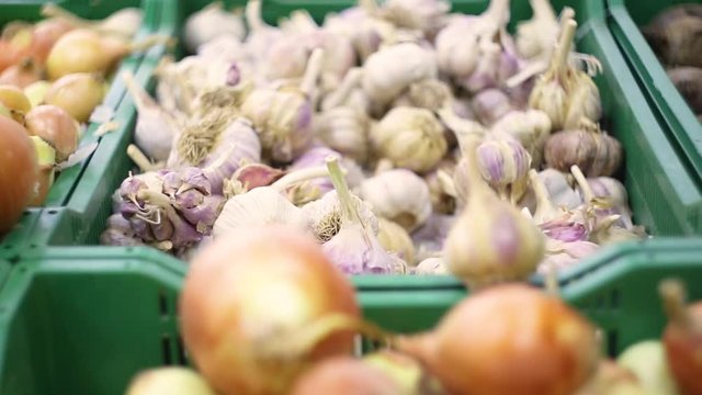 High quality HD video. Healthy fruits and vegetables are laid out in the supermarket. Onions and garlic close-up.