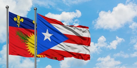 Guadeloupe and Puerto Rico flag waving in the wind against white cloudy blue sky together. Diplomacy concept, international relations.