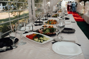 The holiday table cheese, meat, salads. Served table with food. Festive table. Table at restaurant before starting to celebrate. Festive table at wedding banquet. Decor. Details.