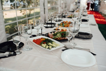 The holiday table cheese, meat, salads. Served table with food. Festive table. Table at restaurant before starting to celebrate. Festive table at wedding banquet. Decor. Details.