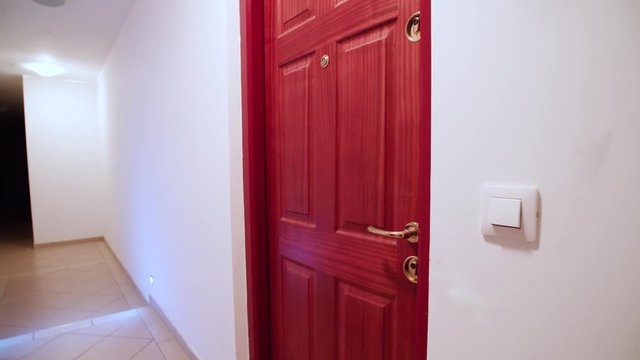 Condo resident front door 4K. Wide shot of the inside of condo hallway with single red door in focus.