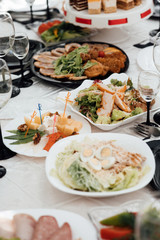 Restaurant table with food. Huge amount of food on the table. Plates of food. Dinner time, lunch. A table full of food in a restaurant. Festively served table at restaurant for a banquet.