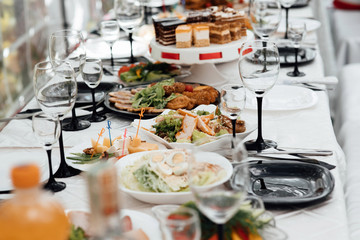 Restaurant table with food. Huge amount of food on the table. Plates of food. Dinner time, lunch. A table full of food in a restaurant. Festively served table at restaurant for a banquet.