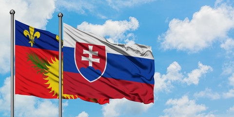 Guadeloupe and Slovakia flag waving in the wind against white cloudy blue sky together. Diplomacy concept, international relations.