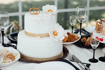 Luxury wedding cake. Holiday cakes for gourmets. Wedding cake. A Wedding cakes stands on the decorated table. The served table at restaurant for a banquet. Restaurant set.