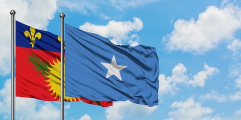 Guadeloupe and Somalia flag waving in the wind against white cloudy blue sky together. Diplomacy concept, international relations.